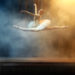 Ballet dancer performing on stage in theatre. There is a fog on the stage.